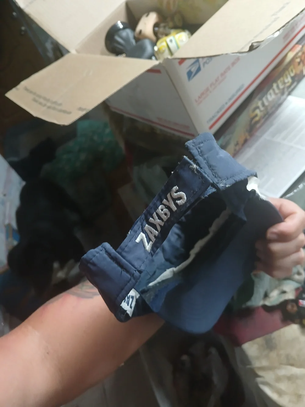 dark blue Zaxby's employee visor featuring a round red patch with a white embroi